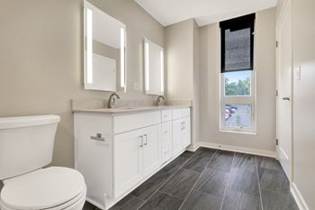 a bathroom with a toilet and a sink and a window